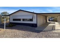 Charming single-story home featuring a covered carport and low-maintenance desert landscaping at 10997 N Hualapai Dr, Casa Grande, AZ 85122