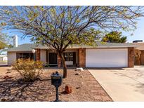 Charming single-story home featuring a two-car garage, brick accents, and a well-maintained desert landscaped front yard at 11451 S Half Moon Dr, Phoenix, AZ 85044