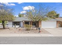 Charming single-story home with a well-maintained front yard and attached two-car garage at 11451 S Half Moon Dr, Phoenix, AZ 85044