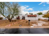 Charming home showcasing terra cotta roof, decorative iron gate, and a well-manicured, low-maintenance yard at 120 E Calavar Rd, Phoenix, AZ 85022