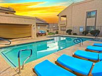 Community pool surrounded by lounge chairs offers a relaxing outdoor space at 145 N 74Th St # 256, Mesa, AZ 85207