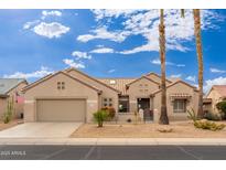 Charming single-story home featuring a two-car garage and desert landscaping in front at 17346 N Escalante Ln, Surprise, AZ 85374