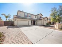 A charming two-story home showcasing a three-car garage, landscaped yard, and a classic tile roof at 2741 E Bridgeport Pkwy, Gilbert, AZ 85295