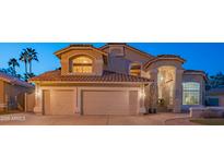 Charming home featuring a three-car garage, well-manicured lawn, and a beautiful tile roof at 7826 W Kerry Ln, Glendale, AZ 85308