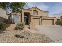 Charming two-story home featuring desert landscaping, a tile roof, and an attached three-car garage at 908 E Mountain Sage Dr, Phoenix, AZ 85048