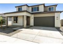 Charming two-story home featuring a neutral color palette, well-kept landscaping, and an attached two-car garage at 15675 W Mercer Ln, Surprise, AZ 85379