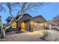 Charming single-story home featuring desert landscaping, a two-car garage, and a welcoming arched entryway at 1828 W Hemingway Ln, Anthem, AZ 85086