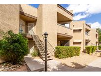 Inviting condo exterior featuring well-maintained landscaping and staircase access to upper units at 2228 N 52Nd St # 117, Phoenix, AZ 85008