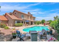 Inviting backyard oasis featuring a sparkling pool, lush landscaping, and comfortable seating areas at 5045 E Redfield Rd, Scottsdale, AZ 85254