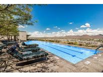 Modern pool with lounge seating, stunning mountain views, and clear blue skies at 7180 E Kierland Blvd # 312, Scottsdale, AZ 85254