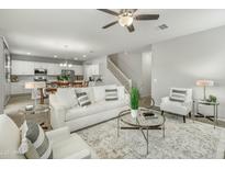 Bright living room boasts a ceiling fan, modern furniture, and blends seamlessly into the dining area at 17176 W Molly Ln, Surprise, AZ 85387