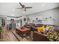 Inviting living room featuring a ceiling fan, plush leather seating, and stylish decor, perfect for relaxation and entertaining at 1951 N 64Th St # 69, Mesa, AZ 85205