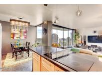 Bright living space featuring city views, modern lighting, and a sleek kitchen with stainless steel appliances at 207 W Clarendon Ave # G18, Phoenix, AZ 85013