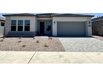 Charming single-story home with stucco facade, desert landscaping, and a gray driveway at 22685 E Saddle Way, Queen Creek, AZ 85142