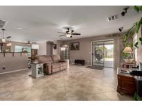 Bright, open living area with neutral colors, tile floors, and sliding glass doors to the outdoor space at 33224 N Cat Hills Ave, San Tan Valley, AZ 85144