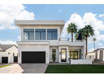 Modern two-story home featuring a black garage door, balcony, and manicured lawn at 4120 N 44Th Pl, Phoenix, AZ 85018