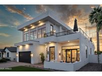 Elegant two-story home boasts a modern design, balcony, outdoor fireplace, and desert landscaping at 4120 N 44Th Pl, Phoenix, AZ 85018