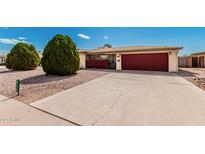 Charming home featuring a large driveway, low-maintenance desert landscaping and a red garage door at 6305 E Adobe Rd, Mesa, AZ 85205