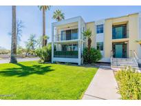 Inviting two-story condo with a well-manicured lawn and mature palm trees, creating a tranquil outdoor space at 6502 N Central Ave # A103, Phoenix, AZ 85012