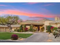 Stunning home with desert landscaping, a circular driveway, and porte-cochere with a beautiful sunset backdrop at 9513 N 129Th Pl, Scottsdale, AZ 85259