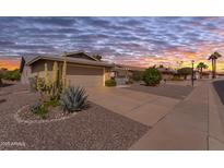 Charming single-story home with a two-car garage and desert landscaping at sunset at 986 Leisure World --, Mesa, AZ 85206