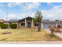 Charming brick home with a well-maintained lawn and a gray two car garage door at 10009 N 36Th Ave, Phoenix, AZ 85051