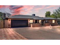 Charming single-story home with a well-manicured lawn, brick driveway, and attached two-car garage at 10602 N 35Th St, Phoenix, AZ 85028