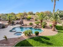 Gorgeous backyard featuring a sparkling pool, relaxing spa, lush palm trees, and a built-in barbeque at 13126 E Turquoise Ave, Scottsdale, AZ 85259