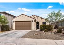 Charming single-story home featuring a brown two-car garage and manicured desert landscaping at 19232 W Madison St, Buckeye, AZ 85326