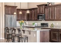 Well-lit kitchen features a large island with barstool seating, stainless steel appliances, and abundant cabinetry at 2124 N 89Th Pl, Mesa, AZ 85207