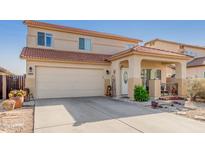 Charming two-story home featuring a tile roof, covered porch and attached two-car garage at 24207 W Desert Bloom St, Buckeye, AZ 85326