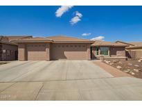 Charming single-story home showcasing a three car garage, neutral color palette and low maintenance desert landscaping at 2842 S Royal Wood --, Mesa, AZ 85212