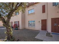 Inviting townhouse featuring a secure entrance and a well-kept lawn with a mature tree at 4625 W Thomas Rd # 19, Phoenix, AZ 85031