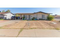 Ranch-style home with xeriscaped yard, covered parking, and a quaint walkway at 8339 W Devonshire Ave, Phoenix, AZ 85037