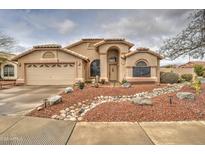 Charming single-story home boasts a well-manicured landscape, cozy front porch, and attached two-car garage at 12450 W Holly St, Avondale, AZ 85392