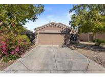 Charming single-Gathering home featuring a well-maintained yard, driveway, and a two-car garage at 12454 W Redfield Rd, El Mirage, AZ 85335