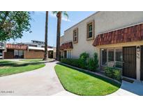 Charming townhouse featuring a well-manicured lawn and walkway leading to the front door at 1320 E Bethany Home Rd # 104, Phoenix, AZ 85014