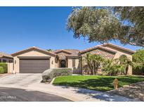 Charming single-story home featuring a stone facade, manicured landscaping, and a spacious driveway at 14870 W Aldea Cir, Litchfield Park, AZ 85340