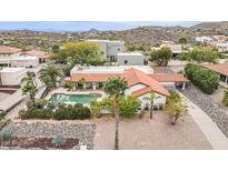 Inviting home featuring a sparkling pool, lush landscaping, and an attached covered carport at 15327 E Thistle Dr, Fountain Hills, AZ 85268