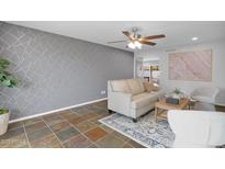 Cozy living room featuring a decorative wall, ceiling fan, and comfortable seating arrangement at 2026 E Duke Dr, Tempe, AZ 85283