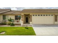 Charming single-story home featuring a manicured lawn, neutral paint, stone accents, and a spacious two-car garage at 2662 S Springwood S Blvd # 458, Mesa, AZ 85209