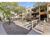 Condominium exterior featuring mature trees, landscaped grounds, walkways, and a bridge entry at 3031 N Civic Center Plz # 339, Scottsdale, AZ 85251