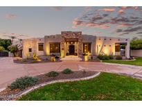 Inviting single-story home featuring stone accents, desert landscaping, and a circular driveway at 4438 E Millbrae Ln, Gilbert, AZ 85234