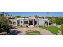 Stunning Santa Fe-style home with beautiful stone accents, desert landscaping, and circular driveway at 4438 E Millbrae Ln, Gilbert, AZ 85234