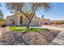 Single-Gathering home featuring desert landscaping, mature tree and two-car garage with tile roof at 9211 W Charleston Ave, Peoria, AZ 85382