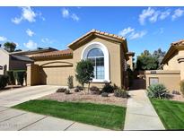 Charming home featuring a tile roof, arched window, well-manicured landscaping, and attached two car garage at 10960 N 78 St, Scottsdale, AZ 85260