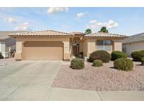 Charming single-story home with a well-manicured front yard and two-car garage, offering curb appeal at 17810 W Club Vista Dr, Surprise, AZ 85374