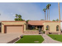 Charming single-story home featuring desert landscaping, a two-car garage, and a red tile roof at 2450 W Keating Ave, Mesa, AZ 85202