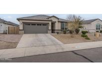 Charming single-story home featuring a grey garage door, neutral stucco, and well-maintained front yard landscaping at 38101 W Santa Maria St, Maricopa, AZ 85138