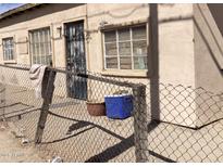 Shows the front of a tan house with a security door and chain-link fence at 5522 E Calle San Angelo St, Guadalupe, AZ 85283